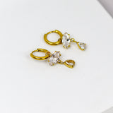 These earrings exude elegance with their dangling marquise and teardrop-shaped stones set in a golden frame