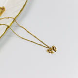 Gold necklace with a Ribbon bow pendant on a white background