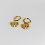Two gold bow-shaped charms hoops on a white background