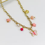 Gold-tone chunky chain adorned with a pastel butterfly, starfish, and bead charms in soft pinks and pearls.
