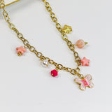 Gold-tone chunky chain adorned with a pastel butterfly, starfish, and bead charms in soft pinks and pearls.