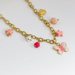 Gold-tone chunky chain adorned with a pastel butterfly, starfish, and bead charms in soft pinks and pearls.