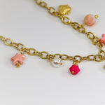 Gold-tone chunky chain adorned with a pastel butterfly, starfish, and bead charms in soft pinks and pearls.
