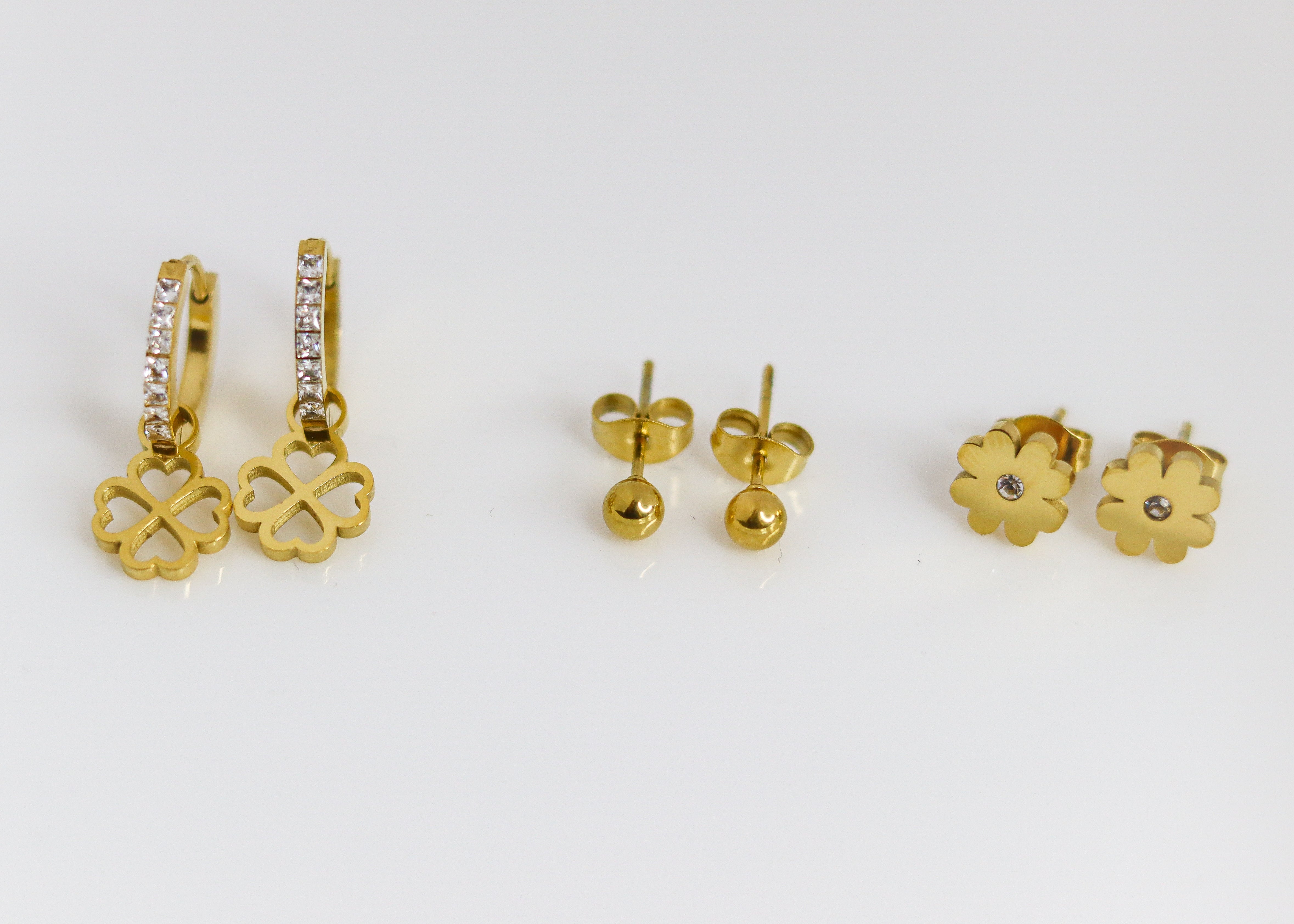 Set of gold earrings on a white background