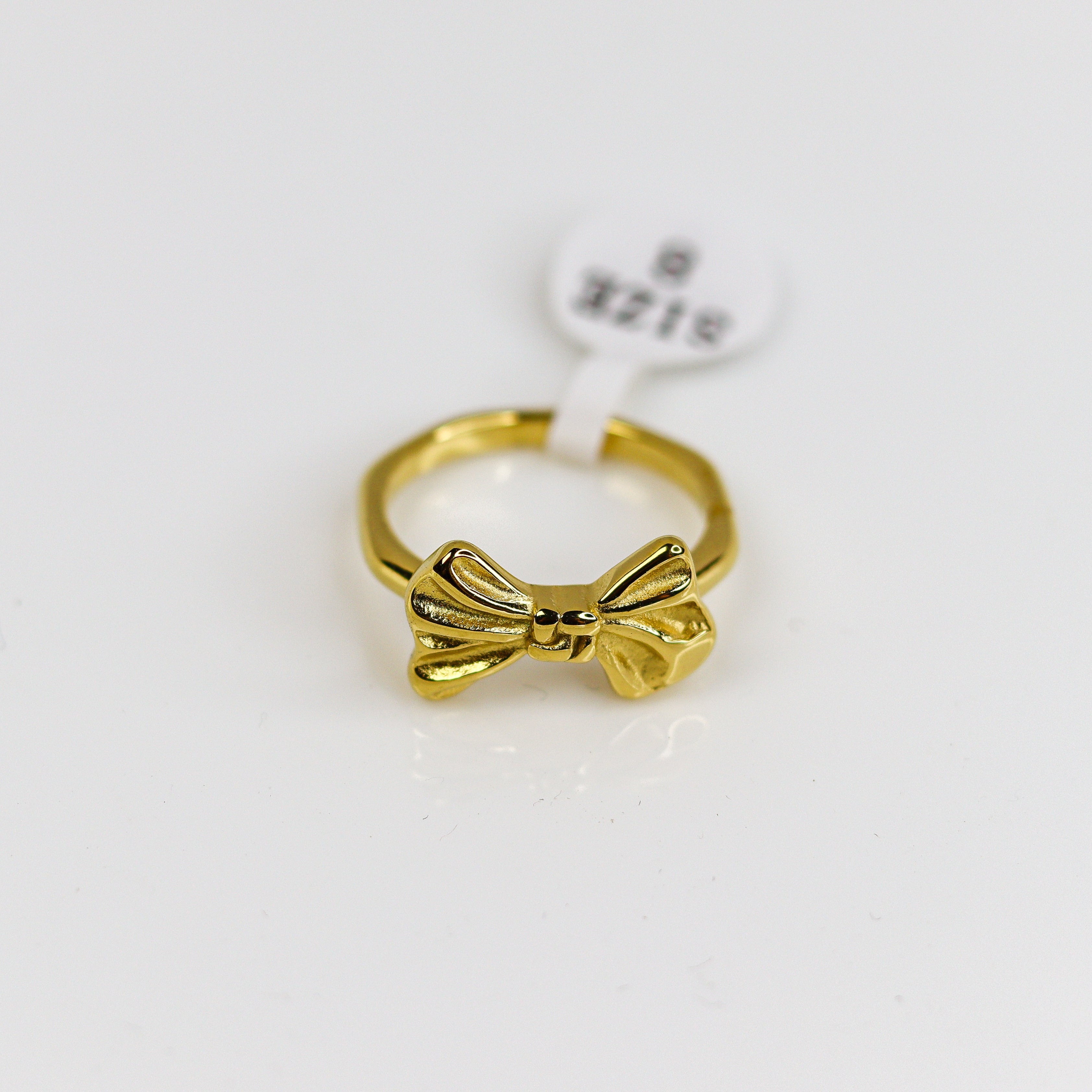 Gold bow-shaped ring  on a white background
