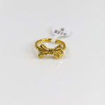 Gold bow-shaped ring on a white background