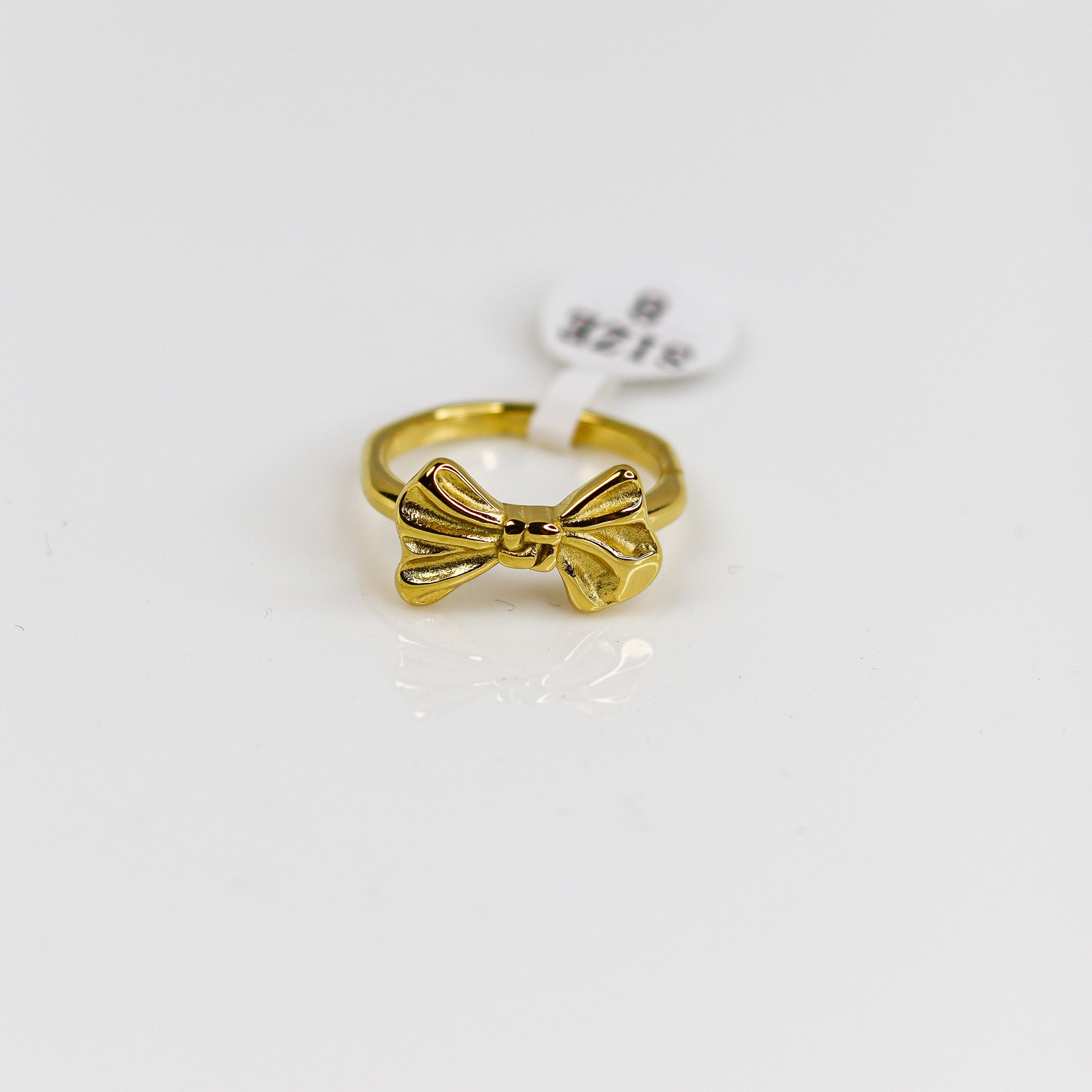 Gold bow-shaped ring on a white background