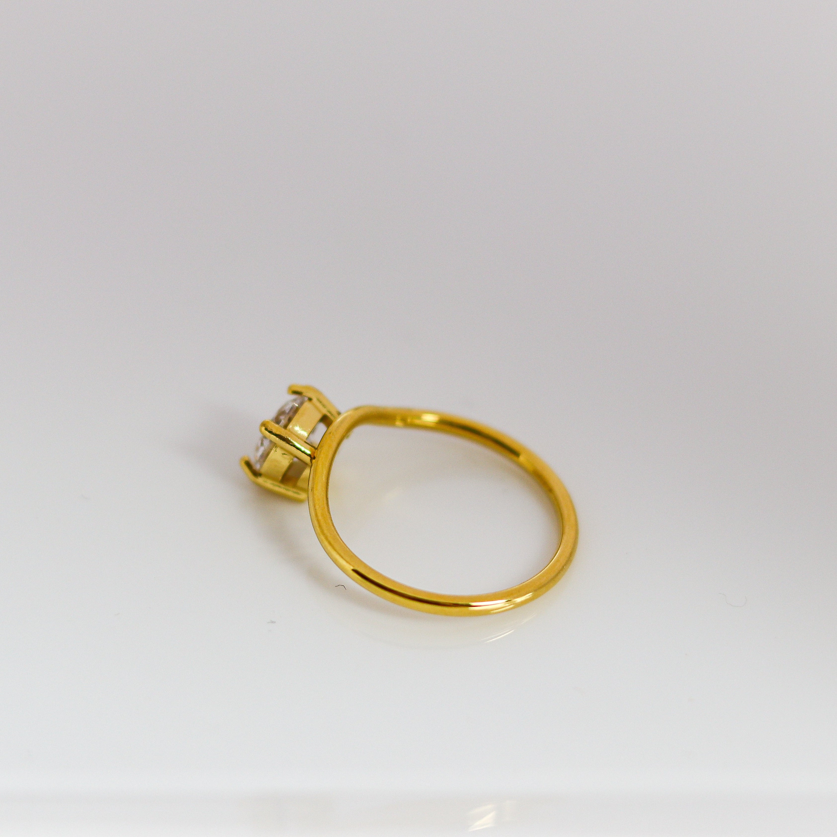 Gold ring with a diamond on a white background