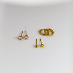 Gold earrings on a white surface