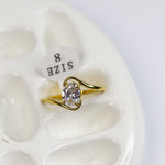 Gold ring with diamond on a white stone surface