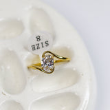Gold ring with diamond on a white stone surface