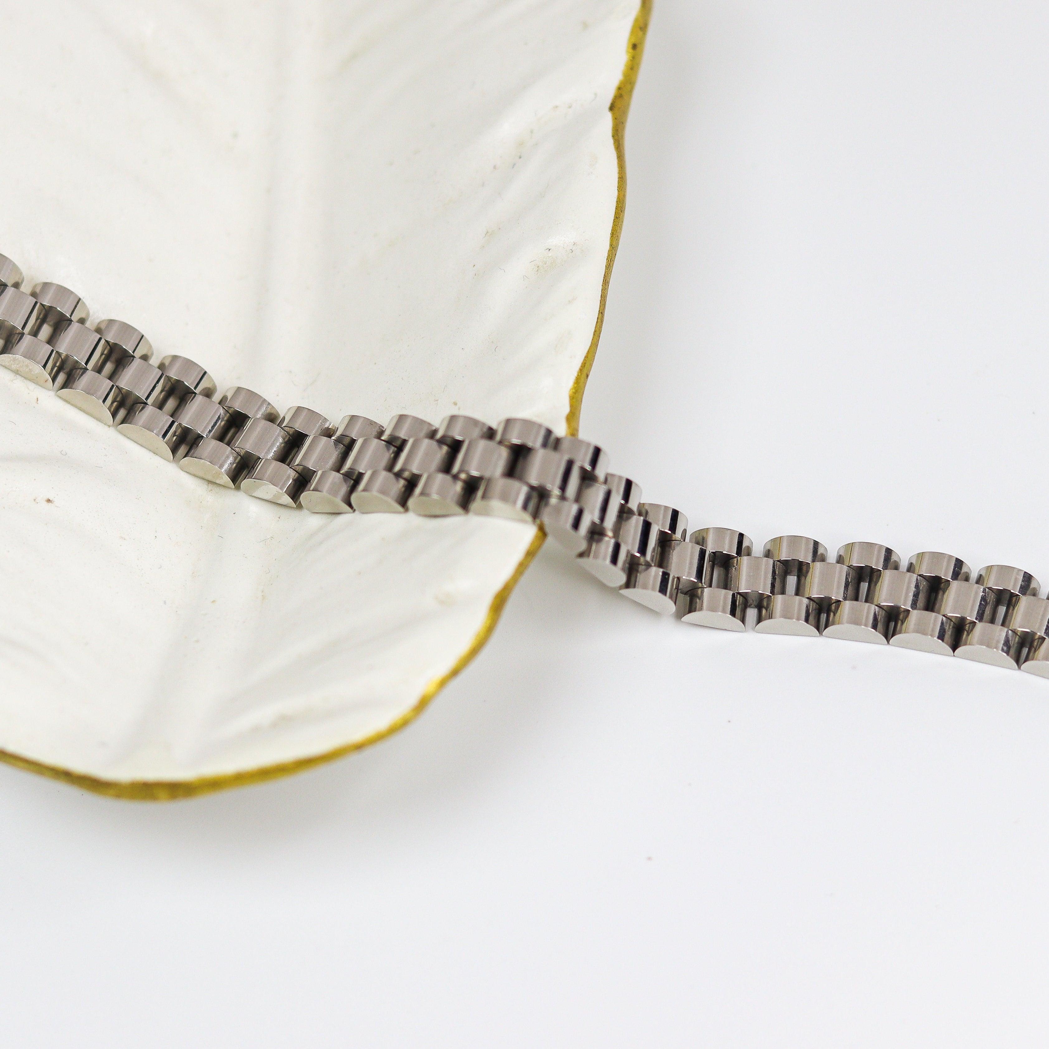 Silver bracelet on a white surface
