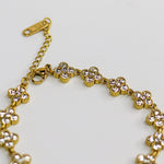 Gold bracelet with floral designs on a light gray background