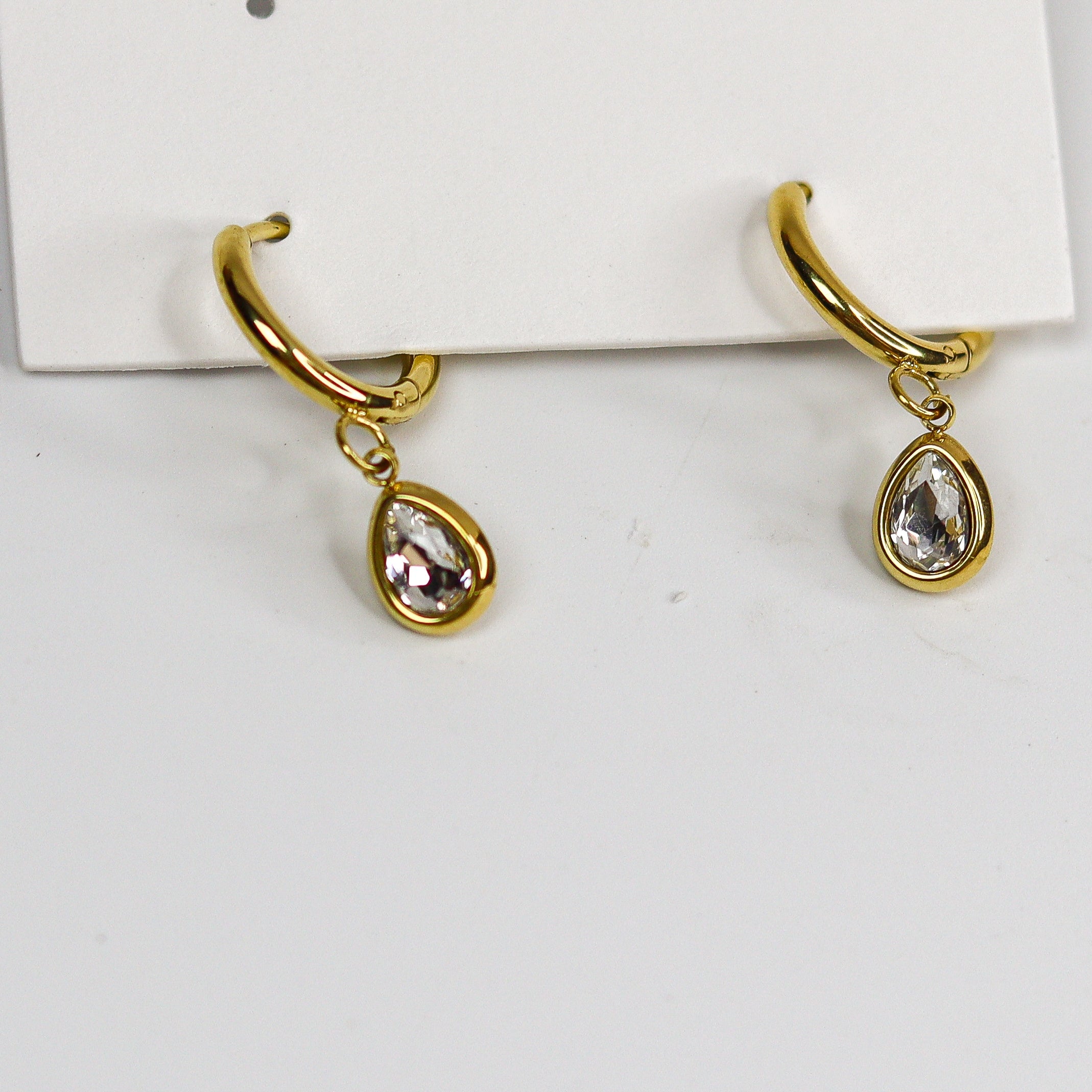 Gold teardrop earrings on a white card with 'Stainless Steel' text.