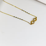 Gold necklace with a heart-shaped pendant on a white surface