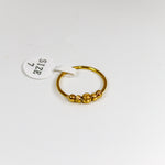 Gold ring with a small round design on a white background