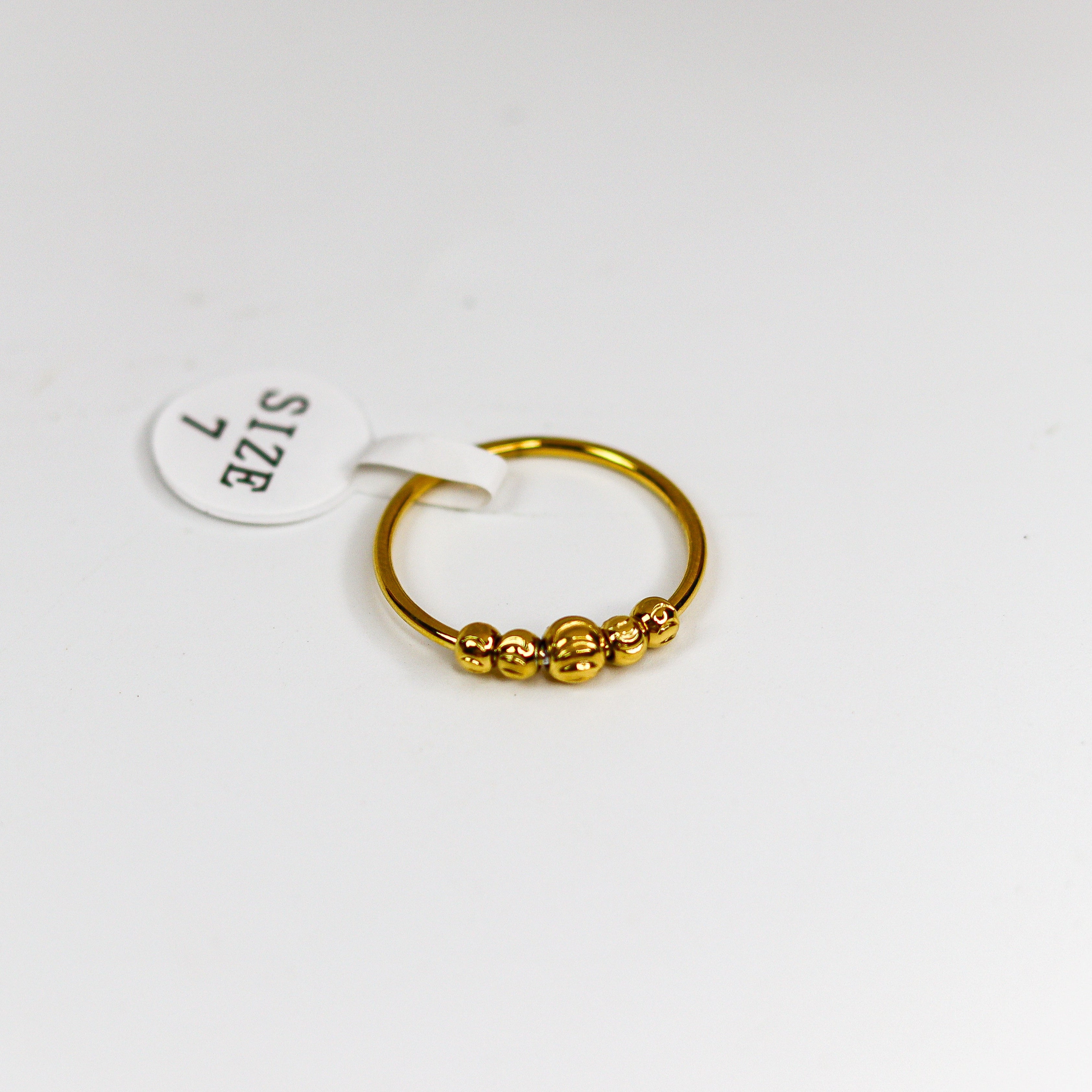 Gold ring with a small round design on a white background
