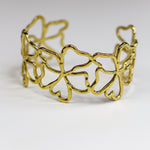 Gold bracelet with a leaf pattern on a white background