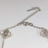 Silver bracelet with floral designs on a light gray background