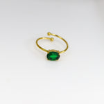 Gold ring with a green gemstone on a white background