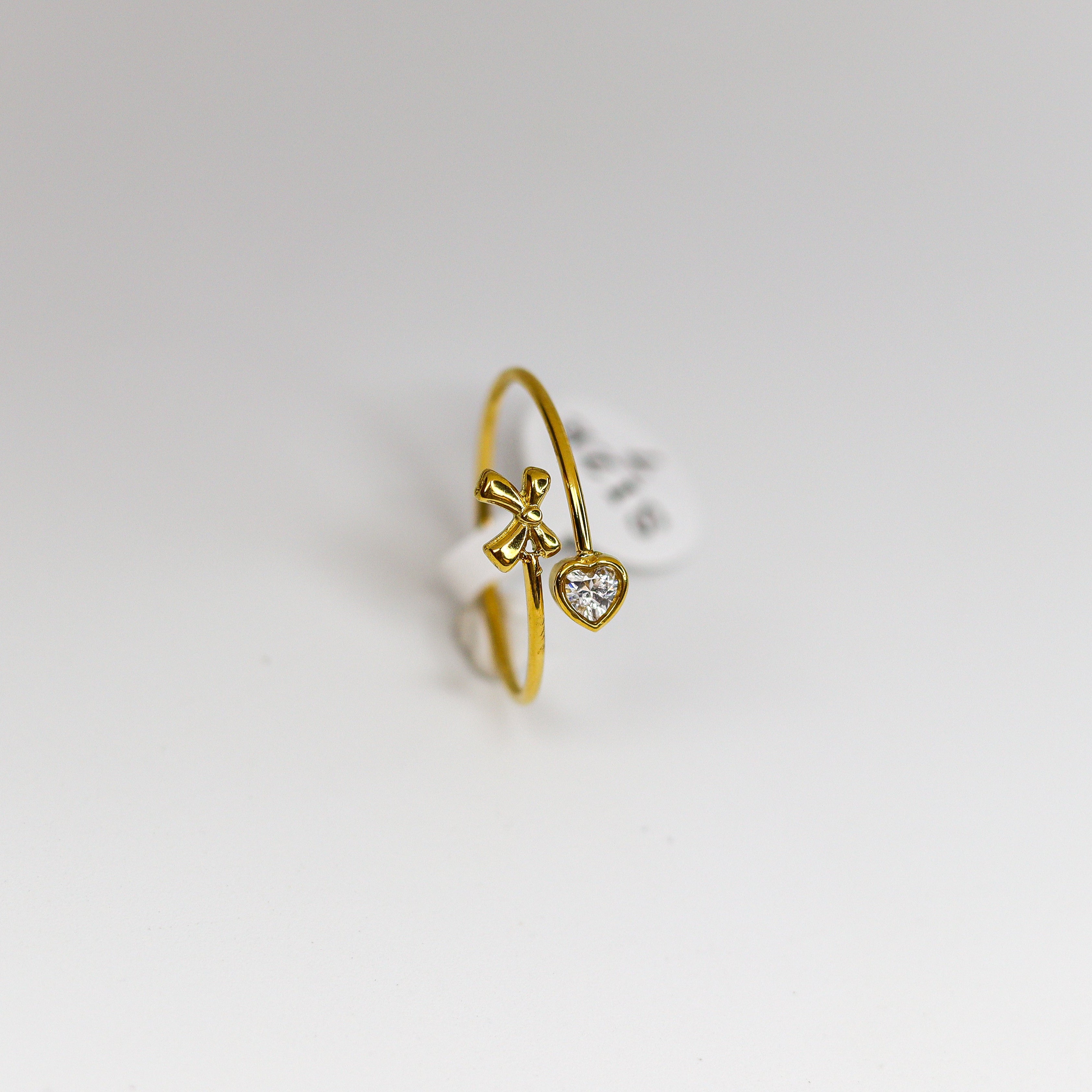 Gold ring with a heart-shaped diamond on a white background