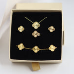 Gold jewelry set including necklace, earrings, and bracelet in a box on a white background