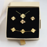 Gold jewelry set including necklace, earrings, and bracelet in a box on a white background